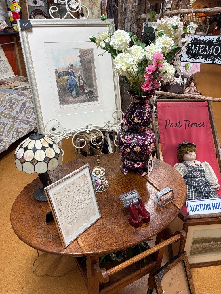 Past Times display with a branded deck chair, business cards and antiques at Waitaki Auction Rooms